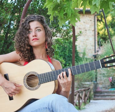 a woman with curly hair and a guitar