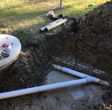 Drain repair with exposed underground pipes during excavation and replacement process