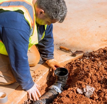 Stormwater drainage installation with plumber fitting underground pipe to prevent flooding