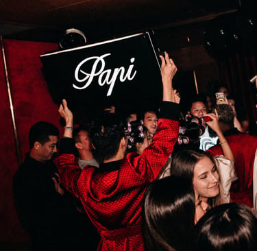 Papi Saigon holding a Papi sign providing Bottle service to clients