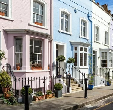 Colorful pastel terraced houses in a charming London neighborhood street with classic bay windows.