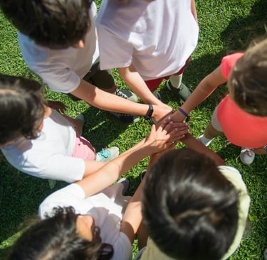 View of girls standing on grass from above  with hands in middle