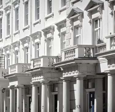 Elegant white Victorian terraced houses in London with classic stucco architecture and pillars.