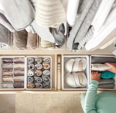 Organized closet drawers with folded clothes, bras, and socks using dividers for home storage.