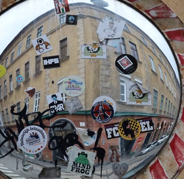 A traffic mirror full of stickers at the corner of Klauzál tér and Dob utca, Budapest, Hungary