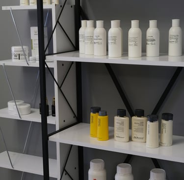 Productos de cuidado del cabello en fondo gris con estantes de herrería negro y blanco.