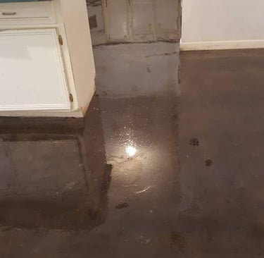a kitchen floor with a wet floor and a sink