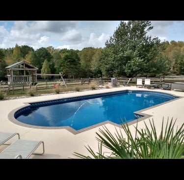 a pool with a lounge chair and a lounge chair
