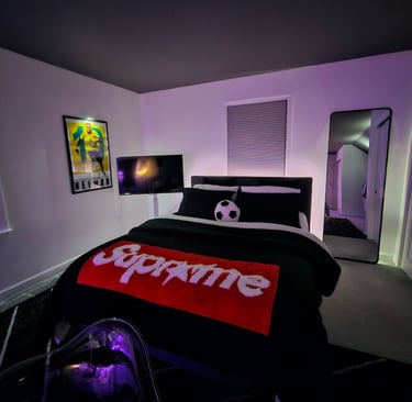 Modern bedroom with Supreme throw blanket, soccer ball pillow, and purple LED ambient lighting.