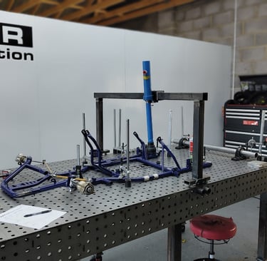 a table with a bunch of tools and kart frame on it