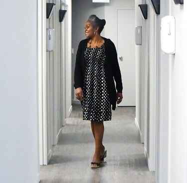 Confident Dr Bisi Aluko walking through modern medical clinic