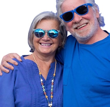Smiling senior couple wearing sunglasses, embracing and looking happy and confident