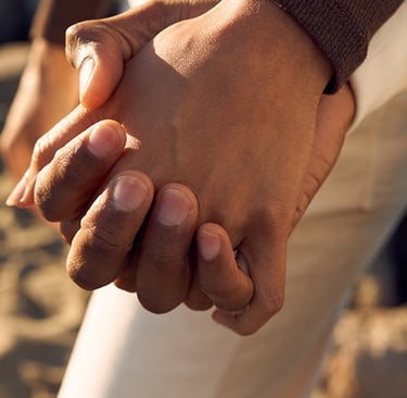 Close-up of two people holding hands representing emotional support, trust, and compassionate care