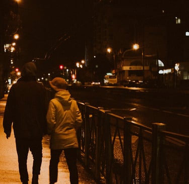 a couple walking down a street at night