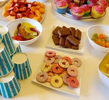 Photo de bonbons, gâteaux, chocolats, gobelets, invitant les jeunes à un goûter