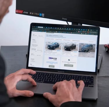 Personne consultant des annonces de voitures d’occasion sur un MacBook
