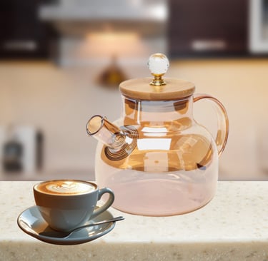 haleira de vidro rosé com tampa dourada ao lado de xícara de café em bancada iluminada.