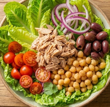 Fresh Mediterranean tuna salad bowl with chickpeas, cherry tomatoes, red onion, and kalamata olives.