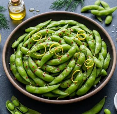 A wooden bowl of steamed edamame topped with lemon zest, sea salt, and chili flakes.