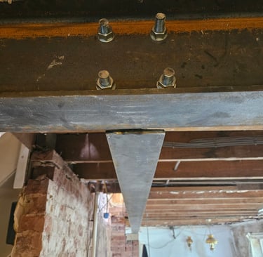 Structural steel beam secured with heavy-duty bolts and nuts for home renovation support.