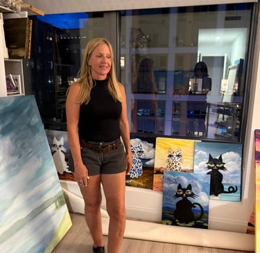 Artist Eve Hennessy in studio with Hawa Cat paintings