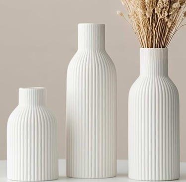 Three white ribbed ceramic vases in different sizes with dried flowers for minimalist home decor.