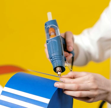 Craft person using a glue sticks in a hot melt glue gun