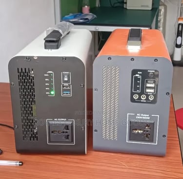 Portable power stations with AC outlets and USB ports on a wooden desk for emergency backup.