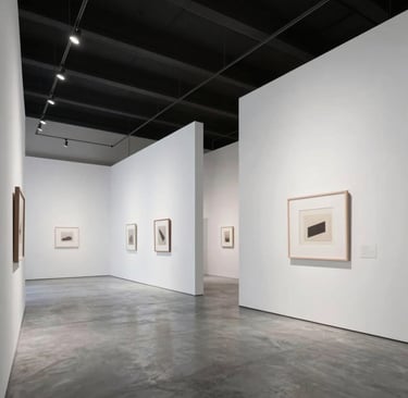 Architectural photography of a minimalist art gallery interior in a Middle Eastern city. The space features stark white walls, polished grey concrete floors, and a massive scale that emphasizes contemporary elegance and artistic focus.