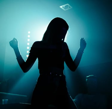 Silhouette de femme dans une soirée aux lumières colorées, ambiance nocturne et sensuelle