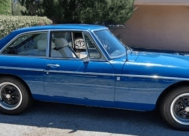 A side view of a 2 door blue MG MGB GT.