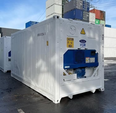 A white Carrier refrigerated shipping container for cold storage transport at a shipping port.