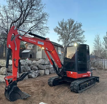 Kubota sitting idle next to completed boulder wall in Ogden, UT
