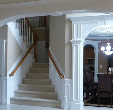 Interior arch and columns framing a staircase and dining room