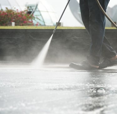 a man Pressure washing the concrete floor