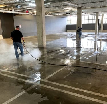 A man pressure washing a commercial garage