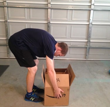 Pessoa abaixando objeto com tronco curvado, postura incorreta para coluna.