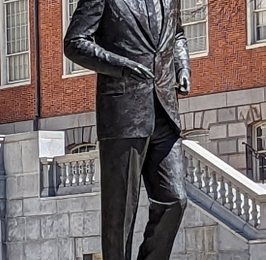 Bronze statue of John F. Kennedy standing outside the Massachusetts State House in Boston.