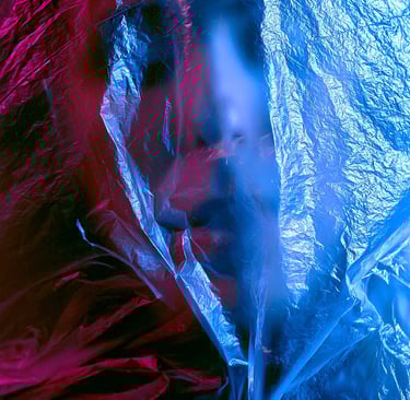 Cinematic portrait of a person behind plastic wrap with blue and pink neon lighting.
