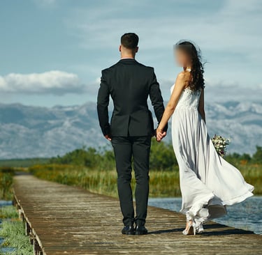 The photo shows a wedding couple holding hands in Nin, with Velebit in the background.