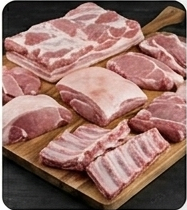 Variedad de cortes de cerdo crudo fresco, incluyendo panceta, costillas y chuletas, sobre una tabla