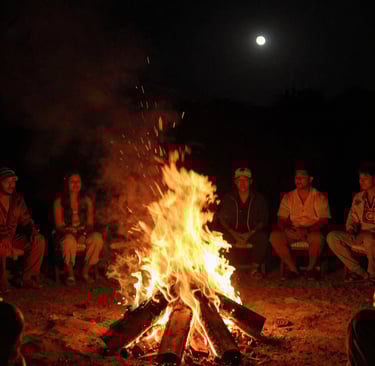 A lively crowd enjoying an outdoor evening event with string lights overhead