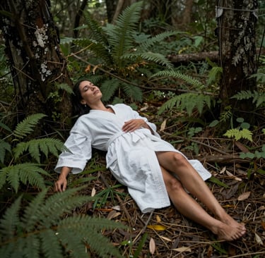 A calm client lying down with eyes closed during a past life therapy session, surrounded by subtle green and gold accents.