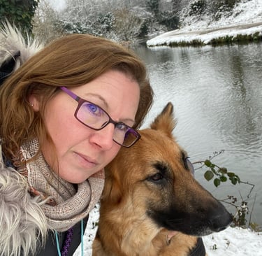 A woman and her German Shepherd dog resting cheek to cheek, sharing a calm and connected moment