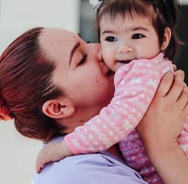 Una madre besando a su bebé sonriente