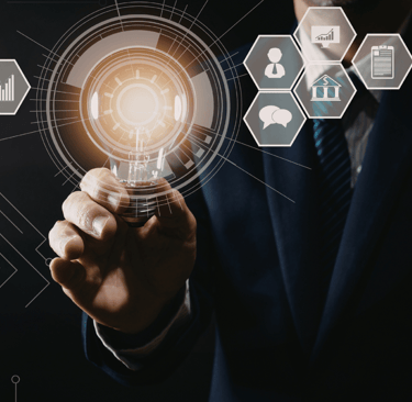 Businessman holding a glowing lightbulb with digital technology icons for business innovation and creative solutions.