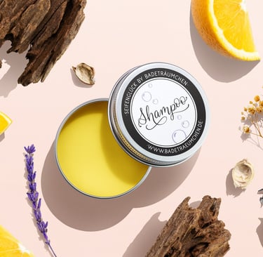 Natural solid shampoo bar in a tin surrounded by fresh orange slices, lavender, and wood.