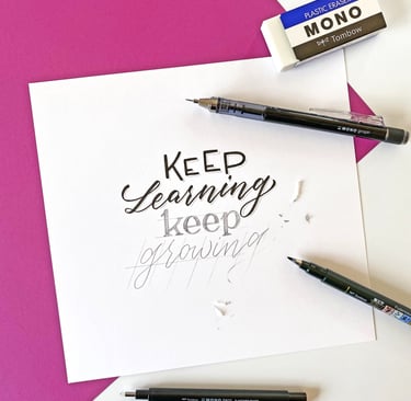 Hand lettering on white paper with a Tombow eraser and pens, featuring the quote Keep Learning Keep Growing.