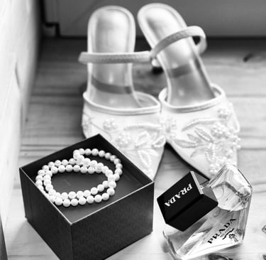 Des accessoires de mariée élégants, notamment un parfum Prada, un collier de perles et des chaussure