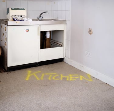 Disused kitchen with word kitchen sprayed on floor